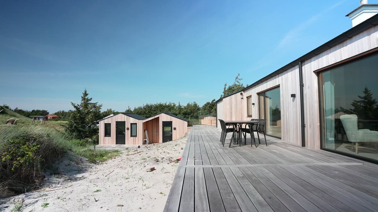 Køkken og alrum med langbord i sommerhuset i Hvide Sande
