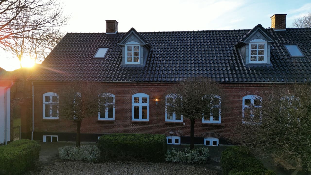 Rødstenshus med kviste i guldlys